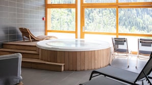 A spa area with a hot tub, wooden steps, and seating. - Apartment in Vaujany Near Alpe D'huez Ski Area (Vaujany)
