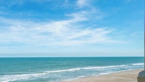 A beach with clear skies and calm water. - Oceanfront Complex | Heated Pool/Tennis | Grnd FL (Cocoa Beach)