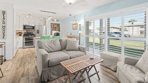 A modern kitchen with white cabinets, stainless steel appliances, and a ceiling fan. - Oceanfront Complex | Heated Pool/Tennis | Grnd FL (Cocoa Beach)