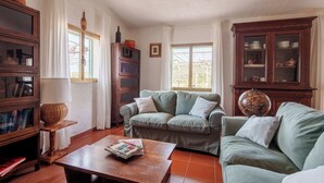 A cozy living room with a green sofa, wooden cabinet, and a globe on a table. - La Villa del Relax - Two Bedroom Villa, Sleeps 4 (Sennori)