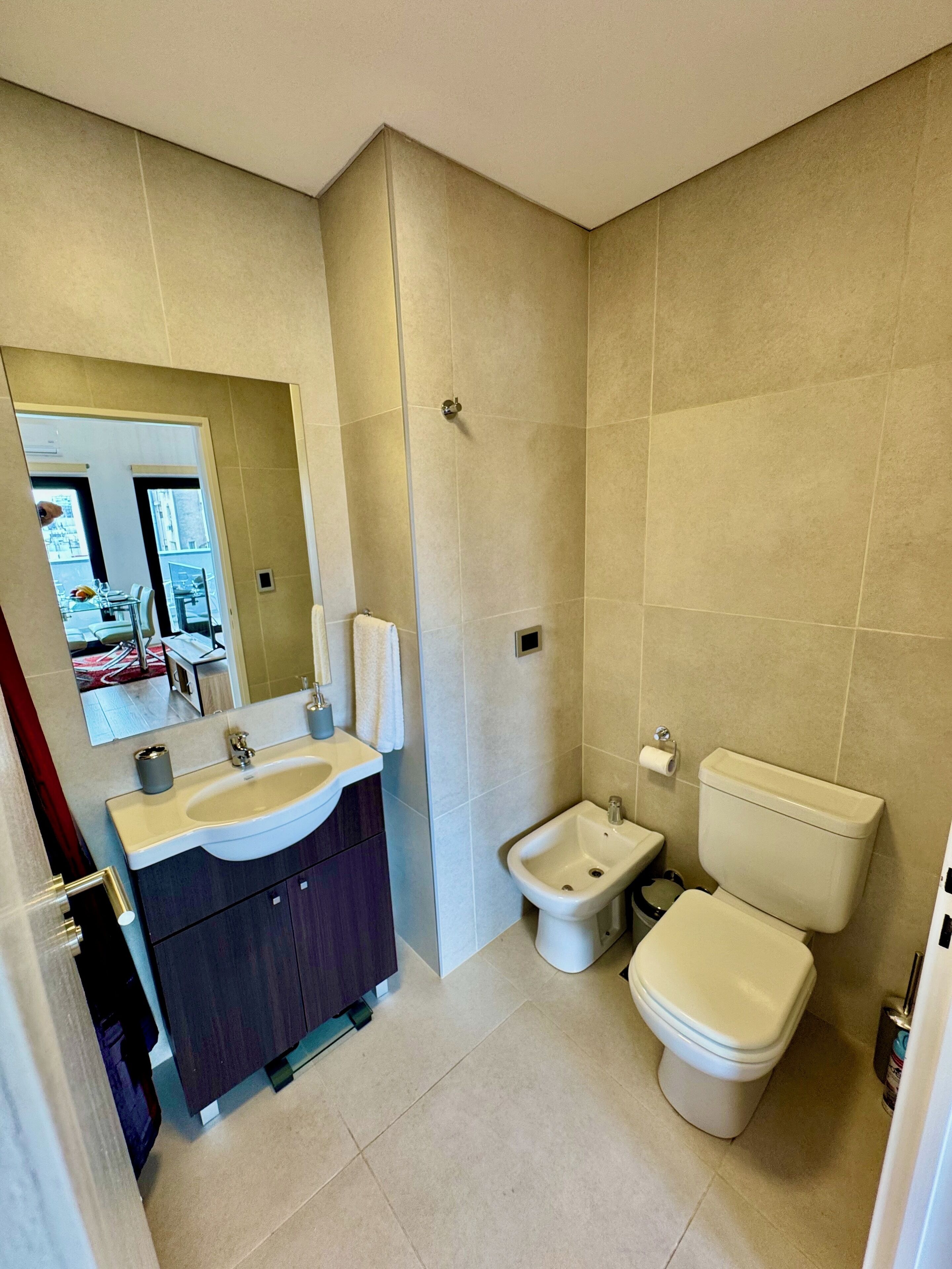 Et moderne badeværelse med vask, bidet og toilet.