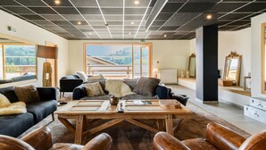 Un espace de détente moderne avec des fauteuils en cuir, une table basse en bois et un canapé agrémenté de coussins.