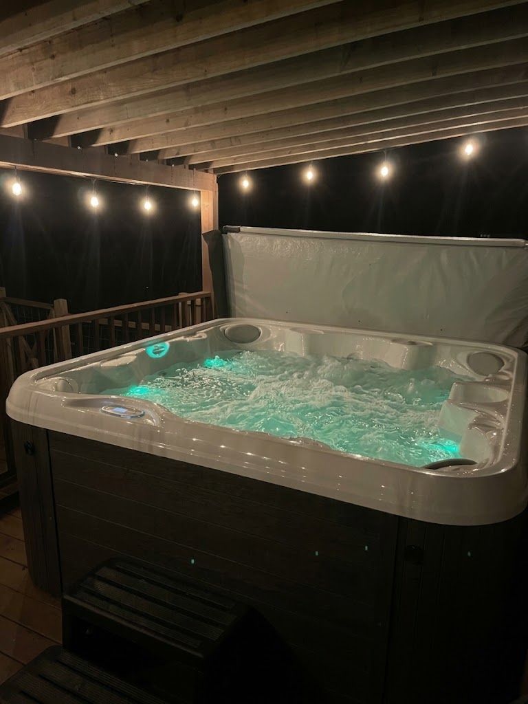 A hot tub with a wooden ceiling and a white cover.
