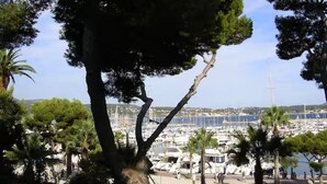 A marina with numerous boats docked, surrounded by trees and a clear sky. - 180° sea view, direct beach access, close to town center (Bandol)