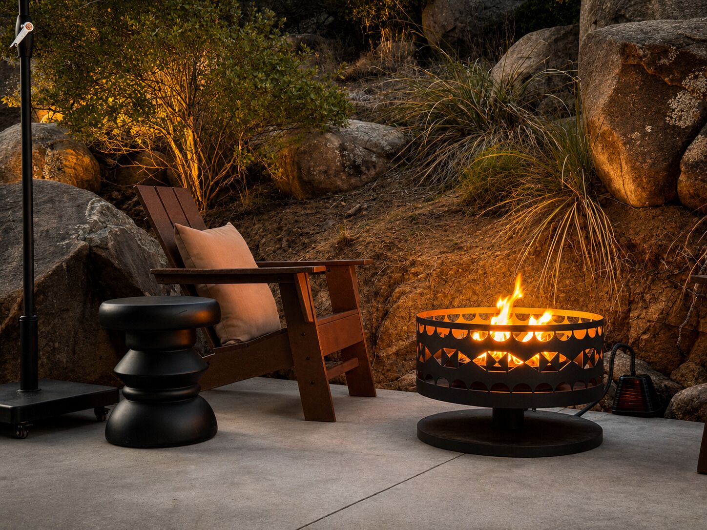 A patio area with a fire pit, a wooden chair with a cushion, and a metal table.