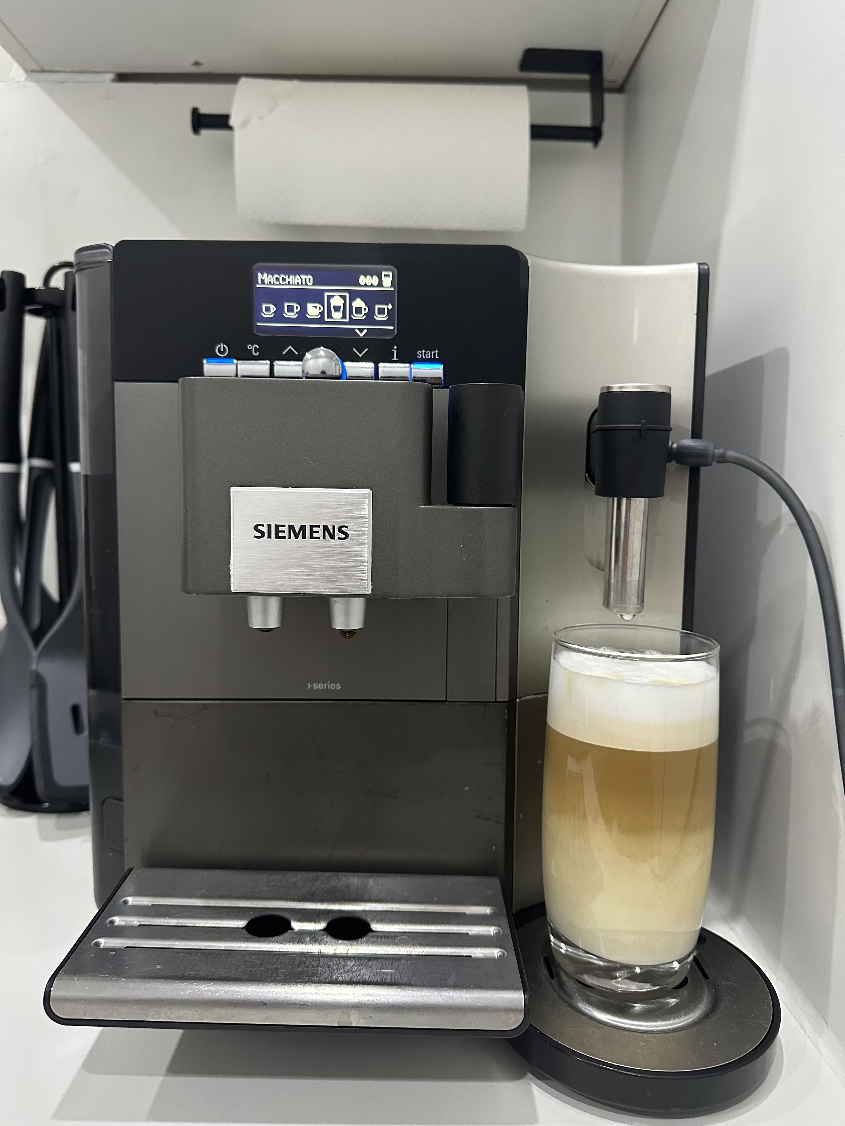 A Siemens espresso machine dispensing coffee into a glass.