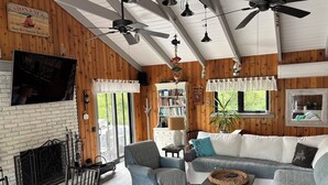 A cozy living room with a fireplace, a television, and a bookshelf.