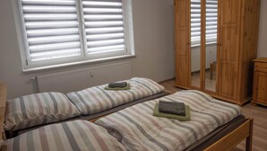 Un dormitorio con dos camas, un armario y una ventana con persianas.