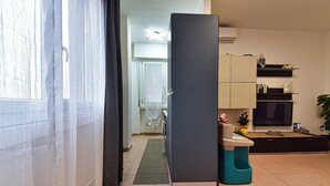 A modern kitchen with a refrigerator, a sink, and a countertop. There is a window with curtains, a door, and a plant. - Whole cozy apartment ;Bright, ideal, for families;Single couples. (Lazzate)