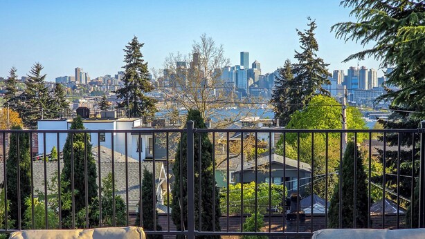 A balcony with two chairs and a view of a city skyline. - Rooftop Lake Union & Skyline Views -- New Eco Home in Wallingford (Seattle)
