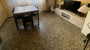 Une petite pièce comprenant une table et des chaises, un téléviseur et un radiateur.