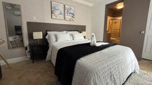 Una camera d'albergo con un letto, un comodino, uno specchio e una cabina doccia.
