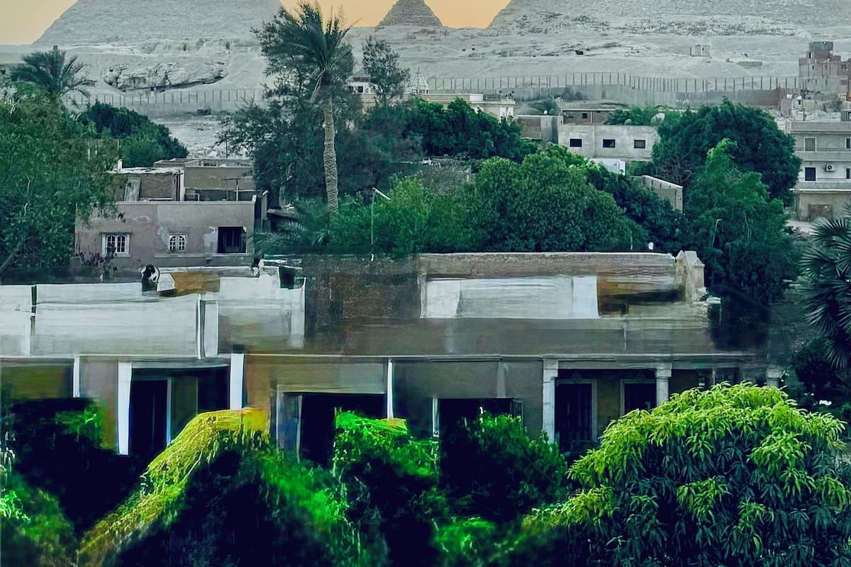 A view of the pyramids with modern buildings in the foreground.
