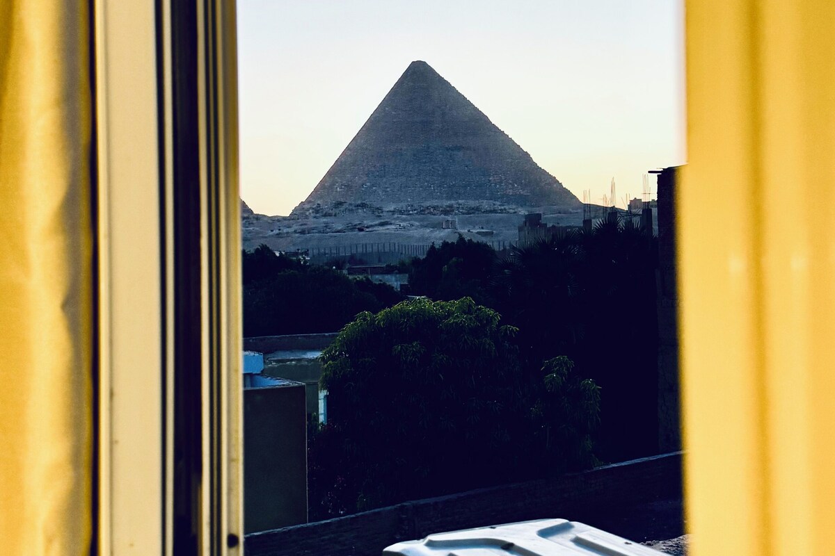 A window view of a pyramid-shaped mountain.