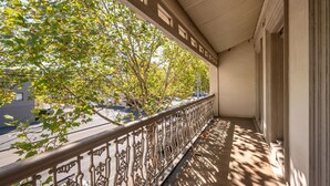 A balcony with ornate metal railings, a view of a tree-lined street, and a building facade with a balcony. - Saint Francis in Fitzroy (Fitzroy)