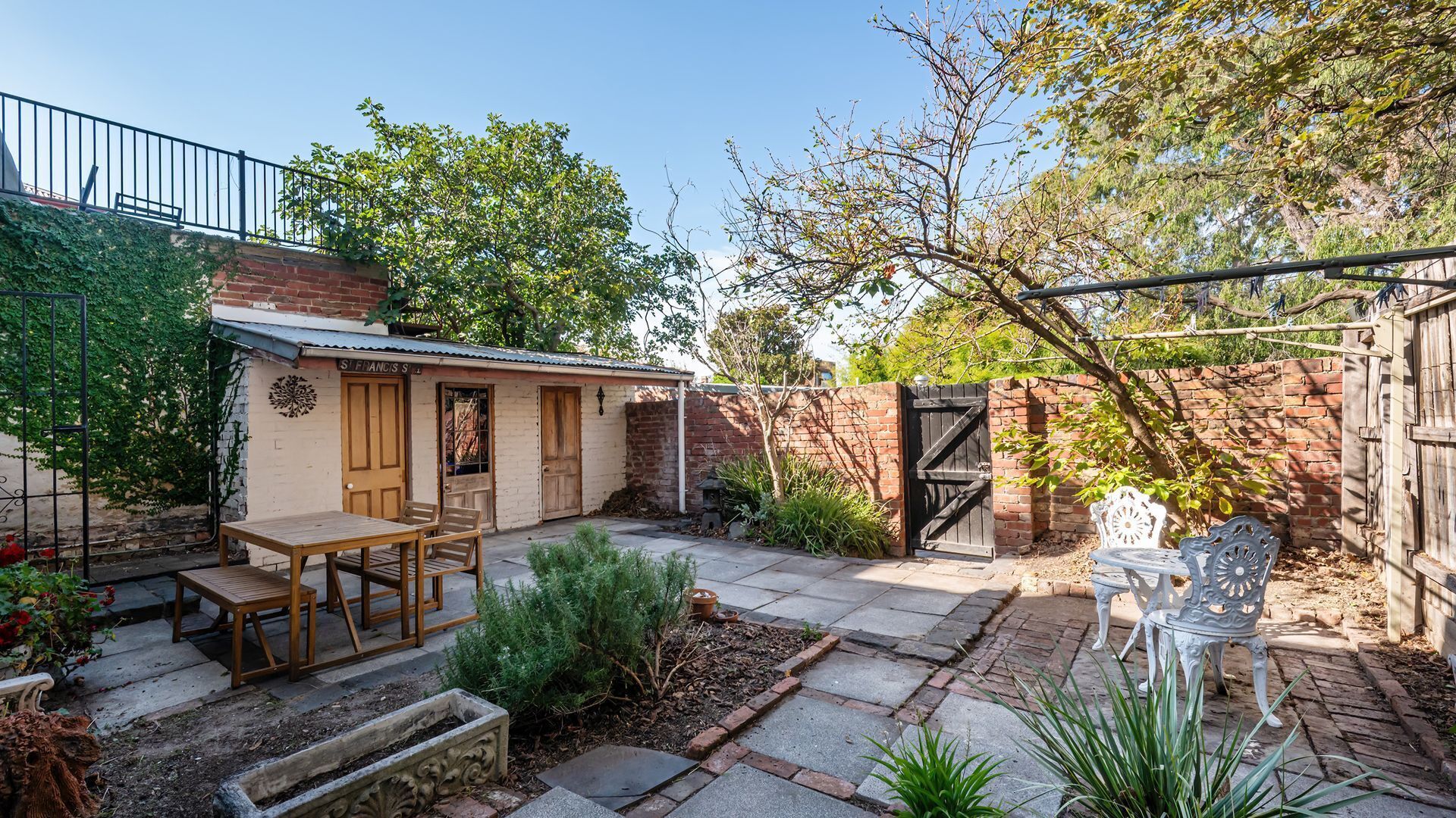 A small, rustic building with a brick exterior and a wooden door labeled "St. Francis St."