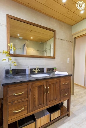 Une coiffeuse en bois dotée d’un grand miroir, d’un lavabo et de plusieurs tiroirs.