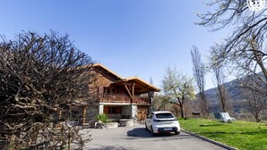 A two-story wooden chalet with a balcony, a stone foundation, and a parked white car in front. - LE CHALET D'YVETTE - LA PLAGNE TARENTAISE (LA PLAGNE TARENTAISE)