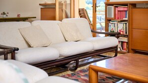 Un soggiorno moderno con un divano, un tavolino in legno e una libreria.