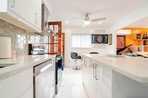 Une cuisine moderne dotée d’un îlot central, d’une cuisinière et d’un ventilateur de plafond.
