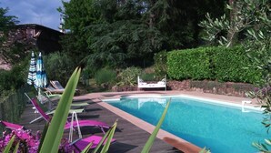 A swimming pool with lounge chairs and a bed, surrounded by greenery and trees. - LE PERCHOIR - LES MAYONS (LES MAYONS)
