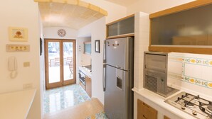Une cuisine équipée d’un réfrigérateur, d’une cuisinière et d’une fenêtre située au-dessus de l’évier.