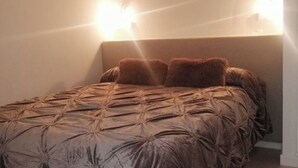 A bed with a tufted headboard and two pillows. - Lacasadesowsam (Granada)