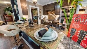 A modern kitchen with granite countertops, a gas stove, and a waterfall wall art. - 6mi from AT&T-HEATED POOL-HOT TUB-INDOOR BAR-TOP KITCHEN AMENITIES-SLEEPS 12+ (Arlington)