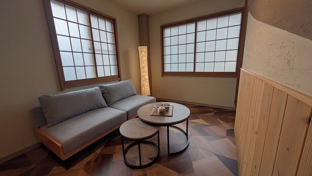 A room with a sofa, a small round table, and two windows with wooden frames. - Tradition x Style 9ppl Rooftop Home near ShinOsaka (大阪市)