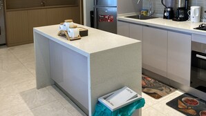 A modern kitchen with a central island, stainless steel appliances, and a microwave. - Chic 1-bedroom apartment in wonderful Nairobi with AC, fitness room, WiFi (Nairobi)