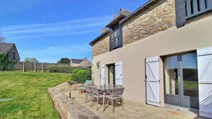 A house with a stone facade, a patio with outdoor furniture, and a clear blue sky. - Des Puits - LOCOAL-MENDON (LOCOAL-MENDON)