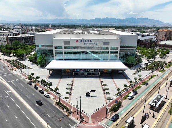 Un grand bâtiment portant l’inscription « DELTA CENTER », entouré de routes et de verdure.