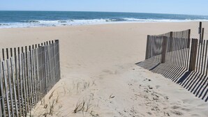 A sandy beach with a wooden fence leading to the ocean. - BeachBox III • Unreal Views • Oceanfront Balcony • Couple's Getaway (Ocean City)