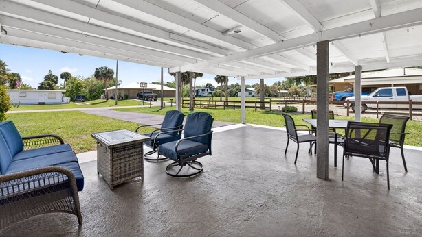 A covered outdoor seating area with wicker furniture and a table. - Quiet Getaway Near Ft. Myers • Relax & Unwind (Alva)
