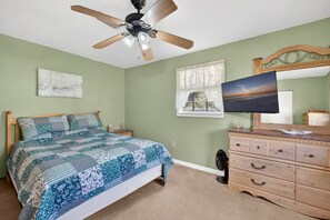 A bedroom with a bed, a dresser, a ceiling fan, a window, and a painting on the wall. - Quiet Getaway Near Ft. Myers • Relax & Unwind (Alva)