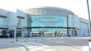 Un bâtiment moderne doté d’une façade en verre incurvée et sur lequel on peut lire en grand « GUILDFORD TOWN CENTRE ».