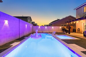A backyard with two swimming pools, a purple wall, and a barbecue area. - 2700sqft/Heated Pool, Hot Tub. 15min to Strip! (North Las Vegas)