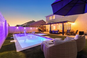 A backyard with a swimming pool, outdoor furniture, and a house. - 2700sqft/Heated Pool, Hot Tub. 15min to Strip! (North Las Vegas)