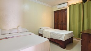 Ein Hotelzimmer mit zwei Betten, einem Kleiderschrank und einer Klimaanlage.