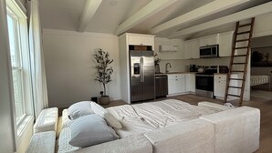 Un loft spacieux comprenant un grand espace de vie, une cuisine et un coin repas.