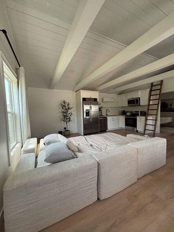A spacious loft with a large living area, a kitchen, and a dining area.