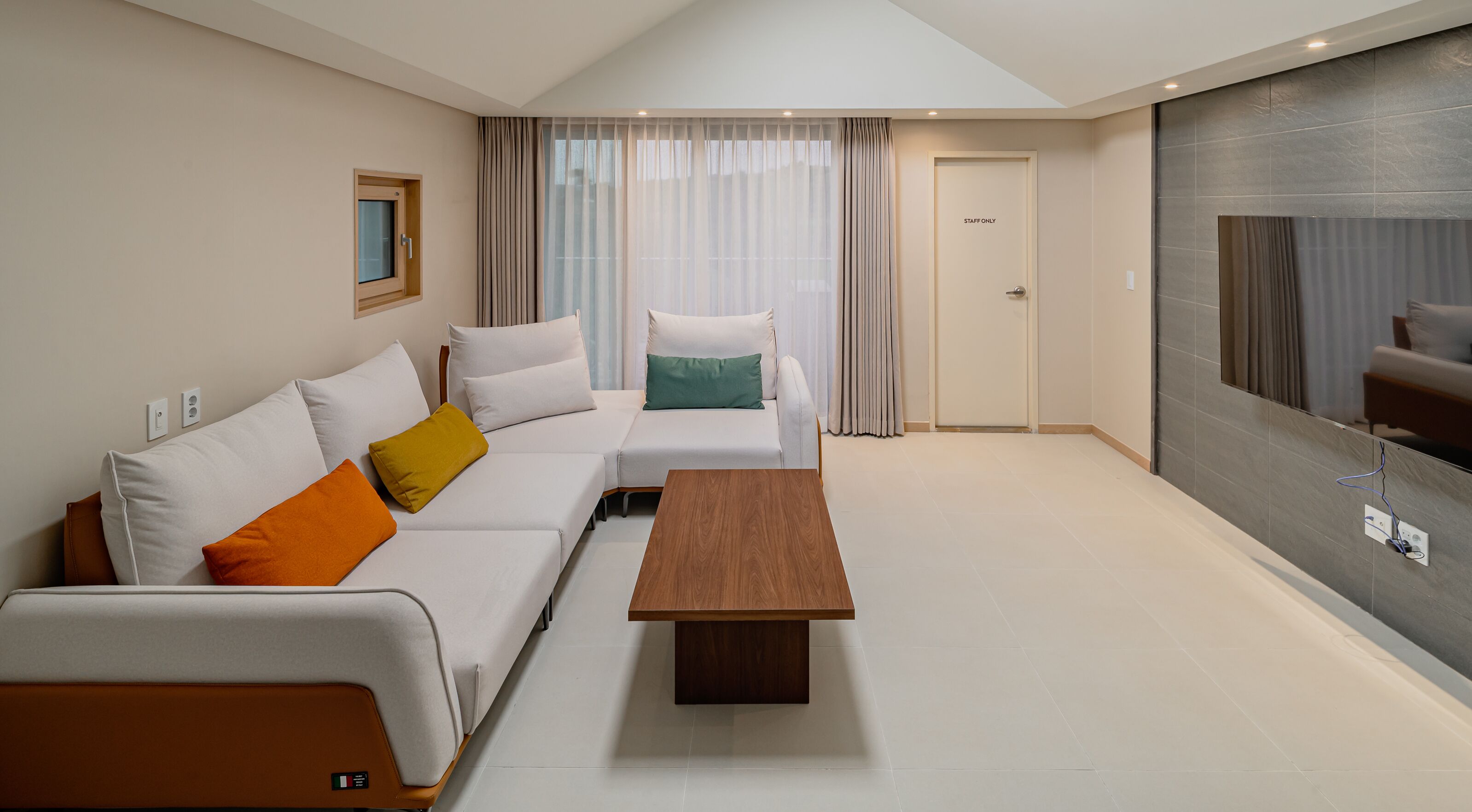 A modern living room with a sofa, a coffee table, and a TV.