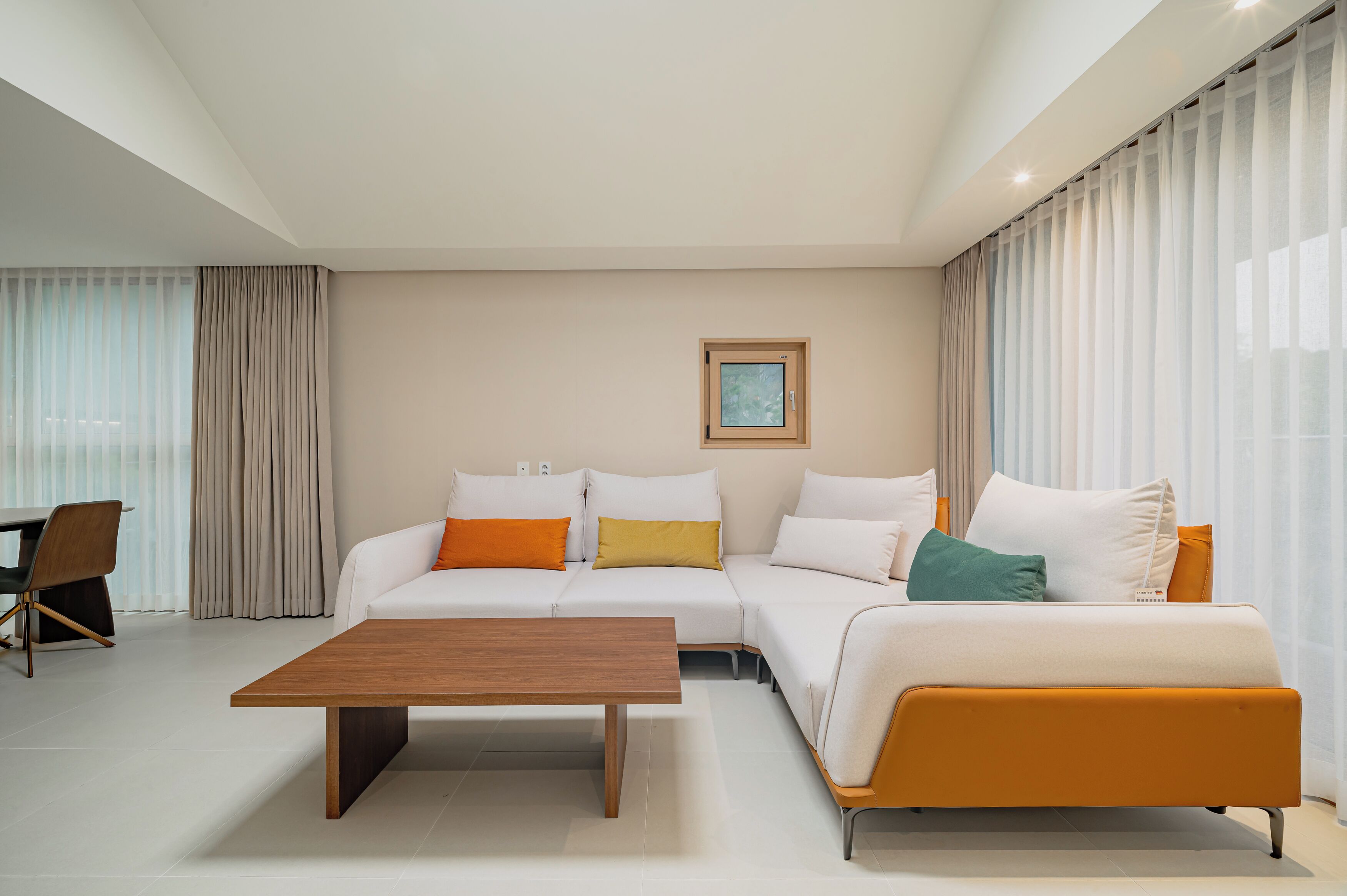 A modern living room with a sofa, a coffee table, and a dining area.