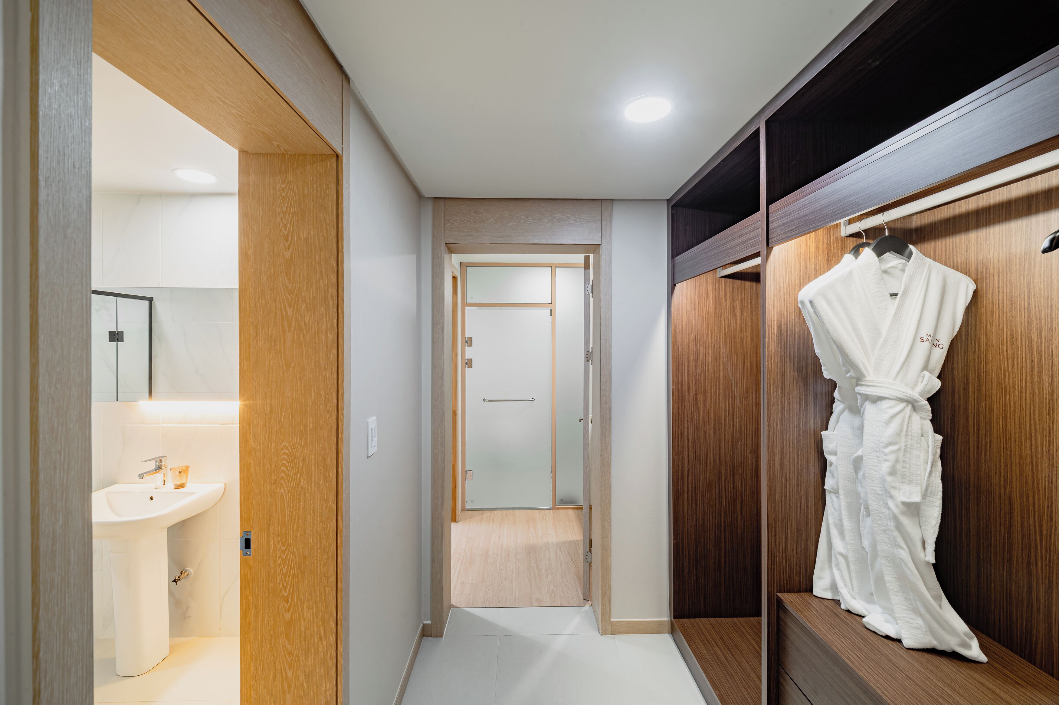 Un baño moderno con lavamanos, espejo y tocador de madera.