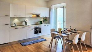 Eine moderne Küche mit weißen Schränken, einem Herd und einem Essbereich mit Tisch und Stühlen.