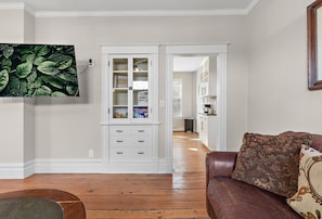 Relax in this stylish living area with a comfortable couch, flat-screen TV, and shelving unit.