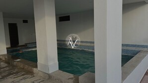 A swimming pool area with tiled walls and a clear view of the pool. - Wake Up to an Ocean View from Your Private Balcony (General Villamil)
