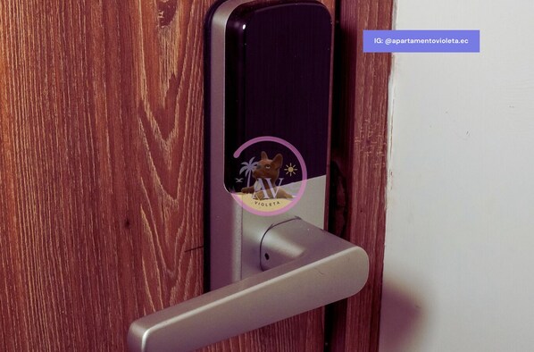 A door with a modern electronic lock and a logo sticker. - Wake Up to an Ocean View from Your Private Balcony (General Villamil)