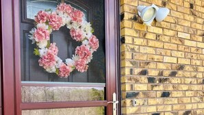 A front door with a glass panel and a decorative wreath.