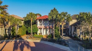 A two-story house with a red roof, surrounded by palm trees and a paved driveway. - 9 Rue Martine in Miramar Beach (Miramar Beach)
